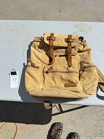 Front view of khaki Ecocity canvas backpack with leather straps and multiple pockets