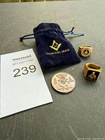 Overview of both rings, coin, and velvet pouch