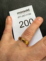 Ring on finger showing gold tone and pattern