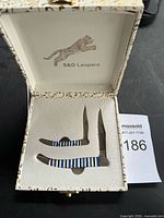 Closed presentation box opened to show two knives seated in formed insert