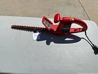 Side view of Homelite corded hedge trimmer showing entire tool, cord, and blade