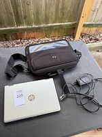 Closed HP laptop, charger and carry bag