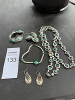 All five jewelry pieces laid out: link bracelet, matching earrings, beaded bracelet, long necklace, teardrop earrings