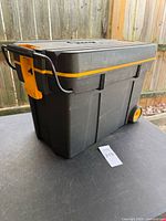 Three-quarter side view showing body, wheels and latch