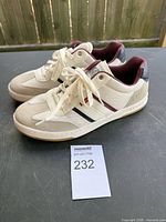 Full view of pair of beige sneakers showing side profile, laces, and color details