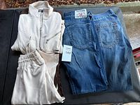 Overall view of jeans and cream track set on table