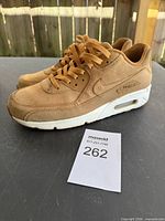 Side view of both sneakers showing uppers, laces, and size tag