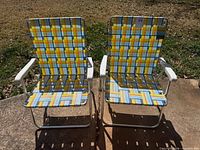 Front view of two matching aluminum folding chairs
