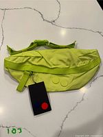 Front of neon yellow pinqponq Brik fanny pack with tag attached