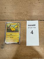 Card in sleeve next to Maxsold lot tag