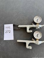 Two Quest Corporation pressure gauges attached to brackets