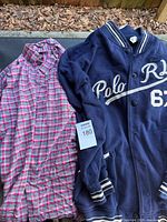 Plaid shirt and navy varsity jacket laid out side by side