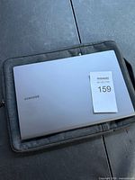 Closed Samsung laptop on grey sleeve