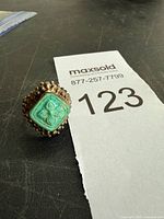 Full view of ring standing showing carved turquoise and beaded border