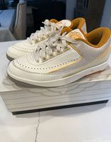 Side view of both sneakers on box