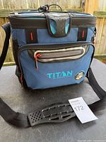 Front view of blue Arctic Zone Titan soft-sided cooler showing strap, pockets and branding