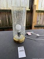 Full view of lamp showing crackle glass cylinder and metal base