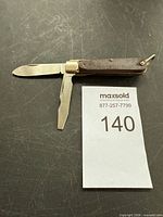 Full view of folding pocket knife open showing both blades and handle