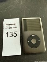 Front view of iPod Classic beside lot tag