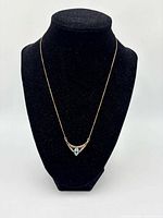 Full view of necklace on display bust showing chain and pendant