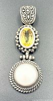 Front view showing citrine, white stone and ornate bail