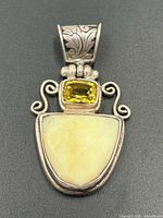 front view showing citrine, cabochon, scrollwork and bail