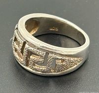 Angled view showing band profile, Greek key cut-outs, interior 925 stamp