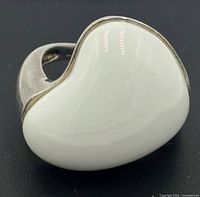 Top view showing white enamel kidney-bean shaped bezel on silver setting