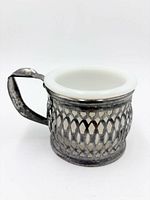 Side view showing silverplate lattice frame and handle with milk glass insert