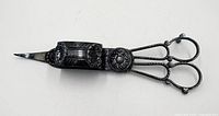 Full view of ornate candle wick trimmer showing catch box and handles
