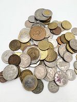 Top view of mixed coin pile displaying variety of sizes, metals and denominations