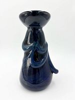 Front view of dark blue art glass vase showing flared rim and raised blue swirls