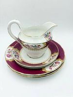 cream jug stacked on matching plates showing pattern and gilt details