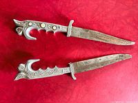 Two matching daggers side by side showing full length and handle details