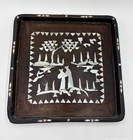 Front of square lacquer tray showing mother-of-pearl inlay scene and border