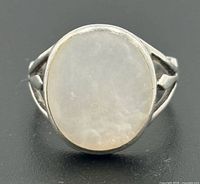 Front view of sterling silver ring with oval white cabochon