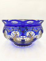 Side view of cobalt blue cut-to-clear crystal bowl showing gold scroll motifs and oval cutouts