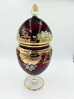 Side view of compote showing ruby glass body, enamel flowers, gold gilt, lid and pedestal