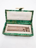 Open brocade box showing soapstone seal inside padded interior