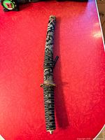 Full view of sheathed tanto showing brocade wrapping and size