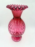 Full view of cranberry glass vase showing dot optic pattern and ruffled rim