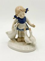 Front view of porcelain girl and ducks figurine