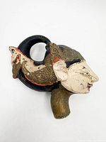 Left profile of puppet head showing carved details and paint