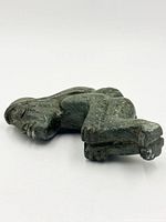 Overall view of carved serpentine figure lying on side