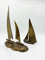 Dual-sailboat brass sculpture and single sailboat shown together