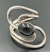 Front view showing sculptural loops and oval onyx