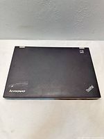 Closed Lenovo ThinkPad T430 top lid showing logo and wear