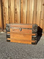 front view of wooden steamer trunk showing latch and metal hardware