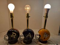 Front view of three helmet lamps lit with bulbs