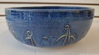 Side view displaying blue glaze and embossed motif